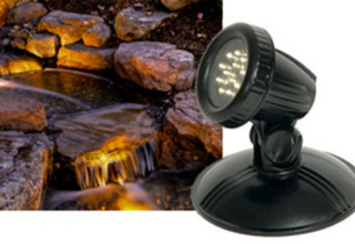 LED pond light illuminates rocks and water.